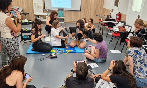 Graciela M. Sterin con un paciente voluntario rodeada de asistentes durante la sesión práctica de aplicación de electroestimulación