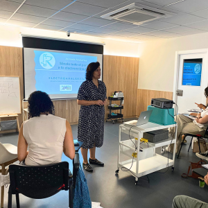 Renata Diniz dando una charla sobre electroanalgesia veterinaria con los asistentes atentos a la conferencia