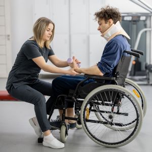 Paciente en silla de ruedas realizando ejercicios con pesas en rehabilitación intensiva.